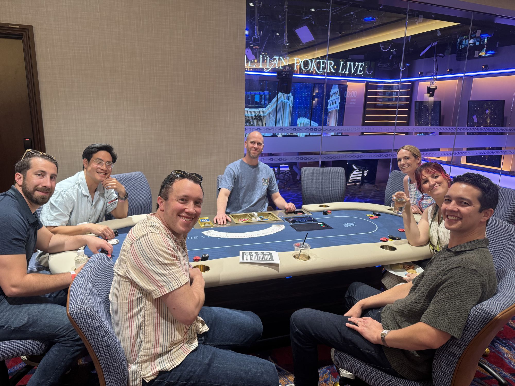 Guests playing poker with a professional host standing beside the table.